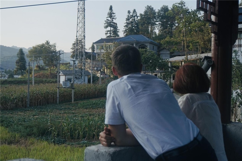 望得見山，看得見水，記得住鄉(xiāng)愁。每個(gè)人心中都有一個(gè)屬于自己的“花茂村”，在這方心田，走遍千山萬水，鄉(xiāng)音未改鬢毛衰。吉爾吉斯斯坦《比什凱克晚報(bào)》第一副總編輯妮娜·尼奇博洛娃與《中國(guó)與俄羅斯》雜志社社長(zhǎng)奧列格·別列日內(nèi)赫攝在花茂村民居屋檐下并肩佇立，眺望山水，尋覓鄉(xiāng)愁。（李光裕攝）