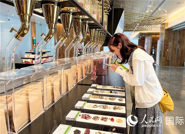 4. 代表團(tuán)團(tuán)員對(duì)新中式茶飲的食材充滿興趣。（人民網(wǎng)記者陳思 攝）