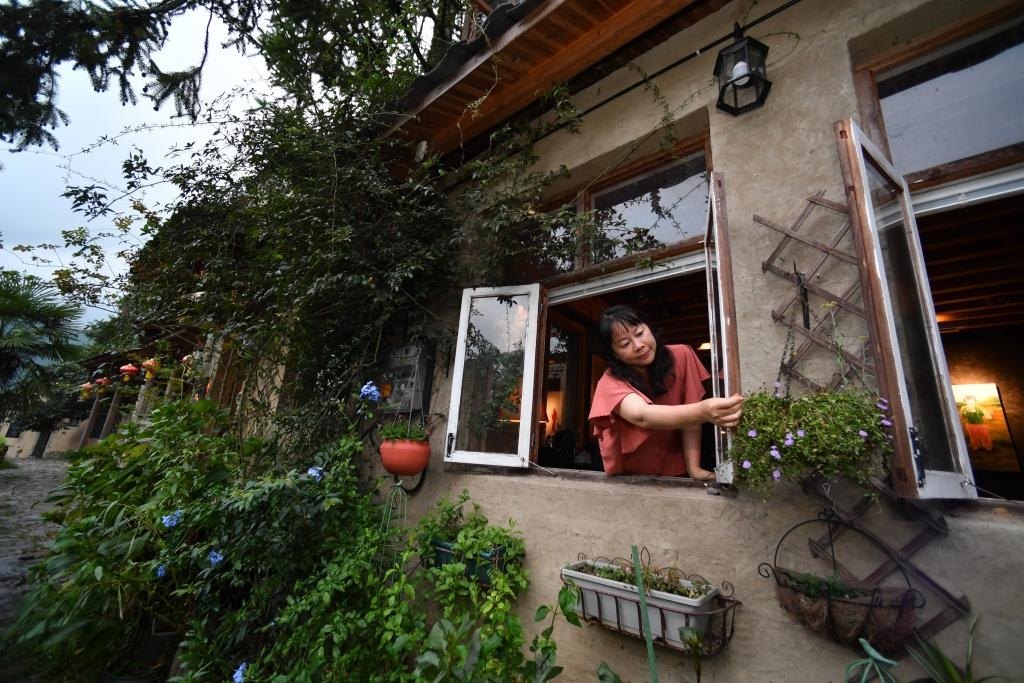 8月29日，在福建省屏南縣熙嶺鄉(xiāng)，龍?zhí)洞濉靶麓迕瘛泵泛暝诖蚶碜约航?jīng)營的民宿外墻裝飾花盆。新華社記者姜克紅 攝