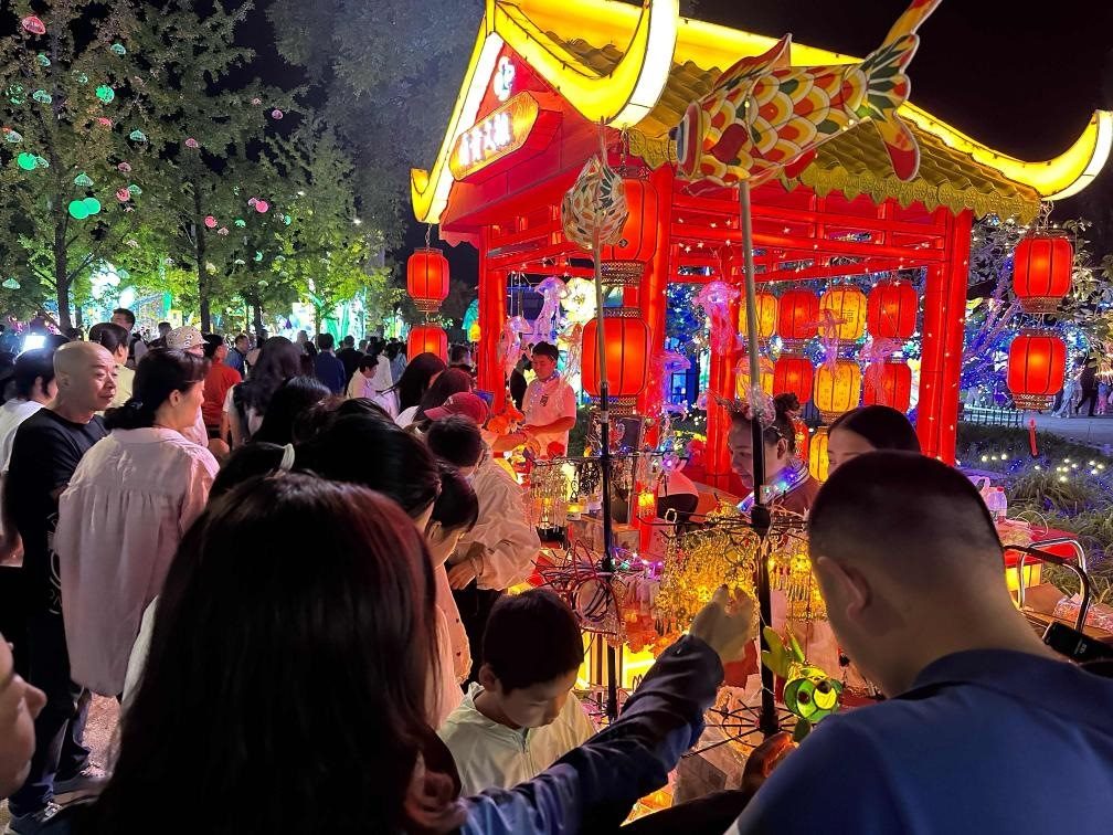 市民游客在2024年北京中秋國慶彩燈游園會上選購特色文創(chuàng)商品。新華社記者楊淑君 攝