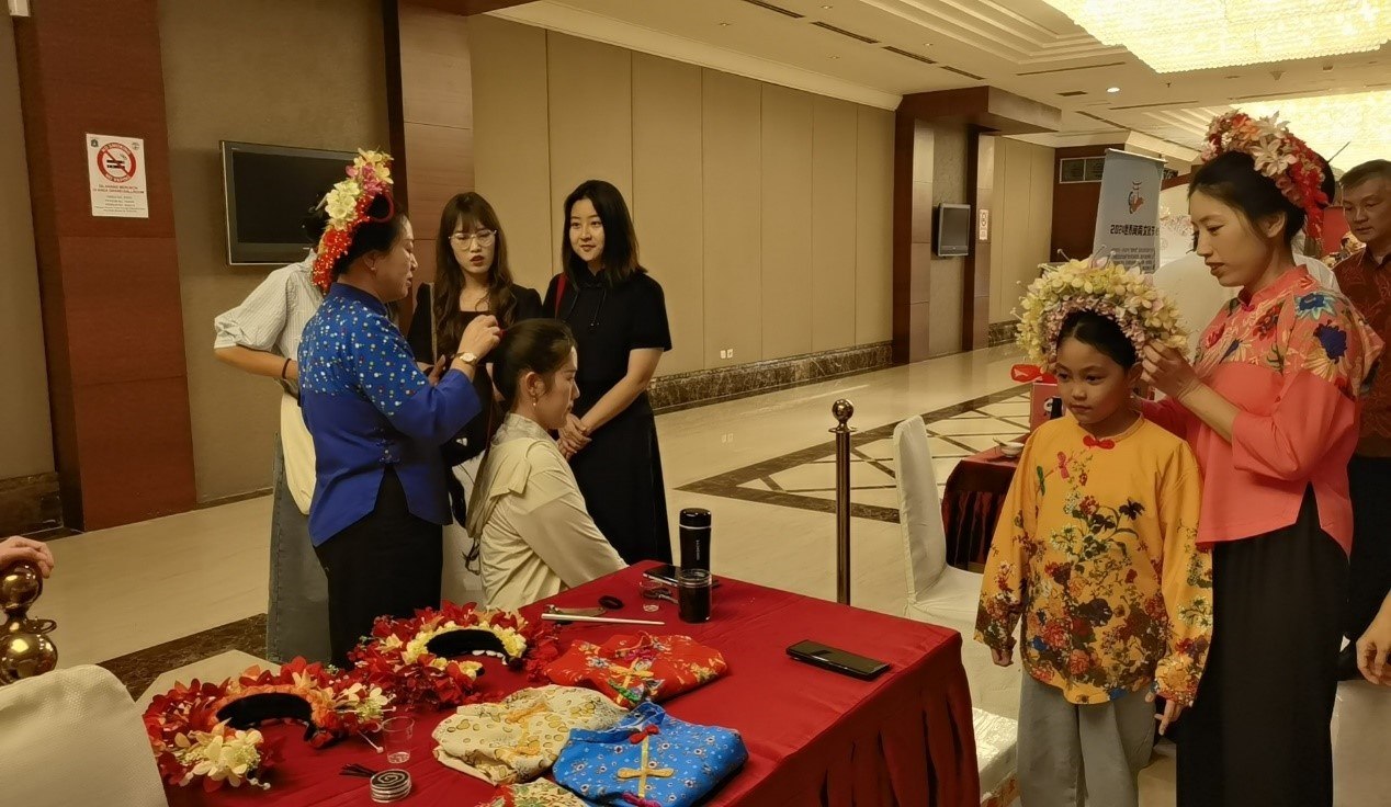 阿拉扎大學(xué)孔子學(xué)院志愿者老師向傳承人學(xué)習(xí)簪花圍。阿拉扎大學(xué)孔子學(xué)院供圖