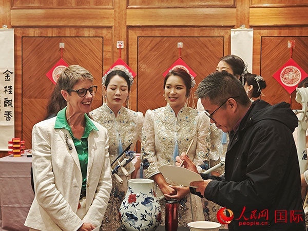 現(xiàn)場的非遺傳承人為英國觀眾展示畫技。人民網(wǎng)記者 邢雪攝