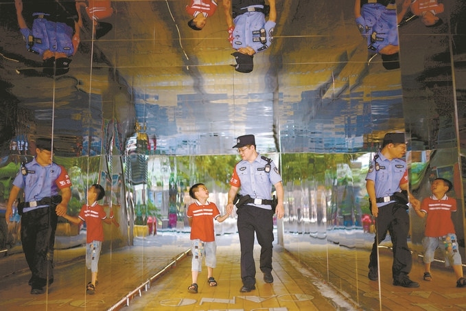 ?7月16日，重慶市公安局江北區(qū)分局一名民警在巡邏途中遇到一個(gè)獨(dú)自玩耍的小男孩，民警將其送回家。王洪平攝