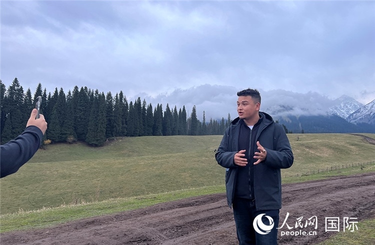 在庫爾德寧，吾買爾江被雪山美景震撼，即興錄制了短視頻作品。人民網(wǎng)記者曾書柔攝