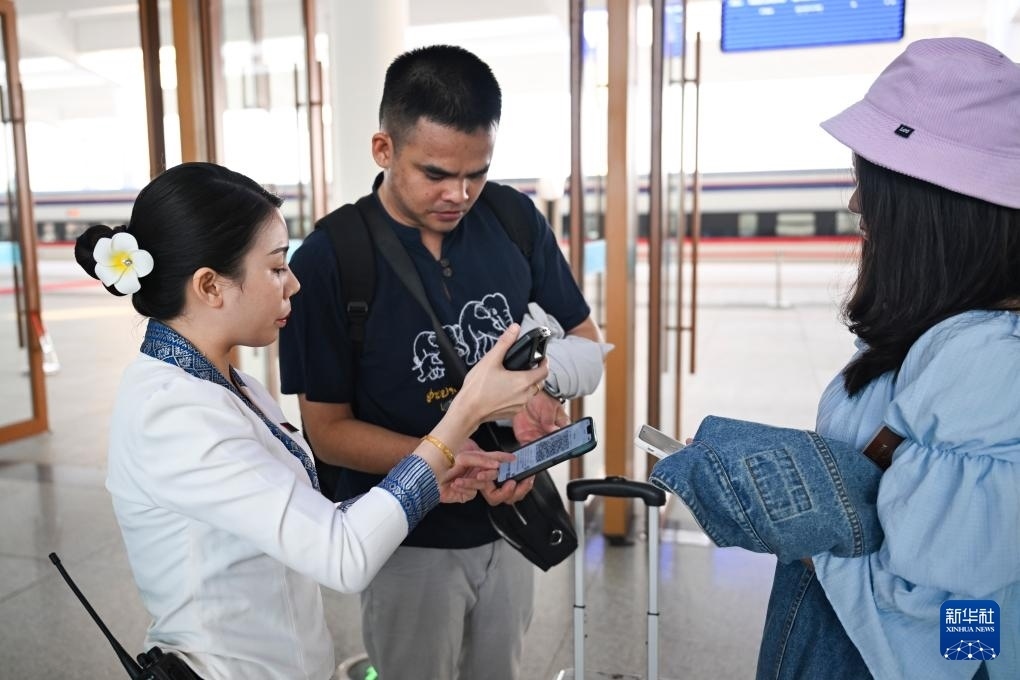 10月12日，在老撾萬象中老鐵路萬象站，工作人員檢驗乘客車票。新華社記者 程一恒 攝