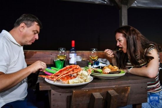 9月2日，食客們?cè)诙砹_斯符拉迪沃斯托克的一家餐館品嘗帝王蟹。新華社記者 曹陽(yáng) 攝