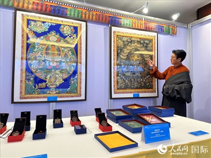 熱貢藝術(shù)國家級(jí)代表性傳承人夏吾角向嘉賓介紹作品。人民網(wǎng)記者 簡承淵攝