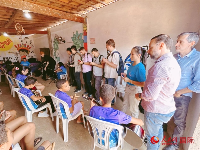  受益于中國企業(yè)的“青少年成長”項目，700多名當?shù)厍嗌倌甑囊魳泛妥闱驂粝氩迳狭顺岚?。圖為聯(lián)合采訪團正在采訪參加音樂培訓的孩子們。 人民網(wǎng)記者 陳一鳴攝