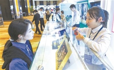 在北京麗澤商務(wù)區(qū)，工作人員（右一）介紹數(shù)字人民幣SIM卡硬錢包。新京報記者 陶冉攝