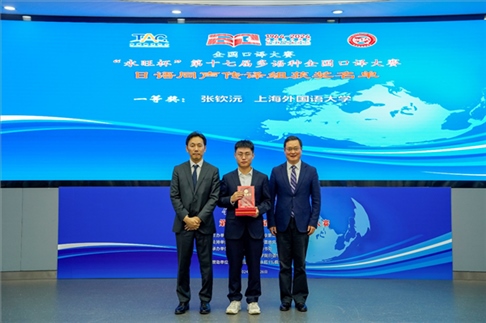 北京第二外國語學(xué)院副院長鄭承軍（右一）、永旺中國投資有限公司集團(tuán)管理總部總經(jīng)理稻垣浩司（左一）為獲得日語同傳組一等獎的上海外國語大學(xué)的張欽沅頒獎。主辦方供圖