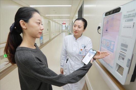 醫(yī)護(hù)人員引導(dǎo)患者在自助機(jī)前辦理自助入院手續(xù)。圖片來源：山東第一醫(yī)科大學(xué)第二附屬醫(yī)院