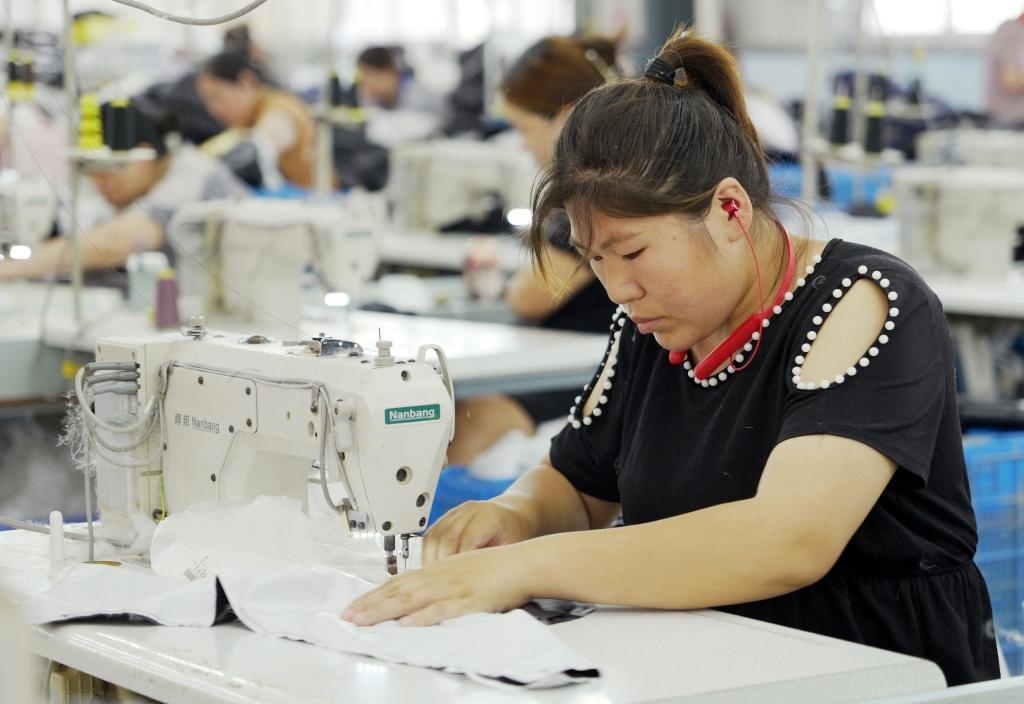 5月20日，村民在李寨村服裝加工廠內(nèi)忙碌。河南省周口市沈丘縣馮營鎮(zhèn)李寨村地處豫東平原。近年來，乘著脫貧攻堅(jiān)與鄉(xiāng)村振興政策的東風(fēng)，李寨村積極探索產(chǎn)業(yè)發(fā)展模式，通過“龍頭企業(yè)+村集體經(jīng)濟(jì)+農(nóng)戶”的方式，逐漸發(fā)展形成肉牛養(yǎng)殖、設(shè)施農(nóng)業(yè)、服裝加工、康養(yǎng)民宿等產(chǎn)業(yè)，以產(chǎn)業(yè)振興助力鄉(xiāng)村振興。新華社記者 李嘉南 攝