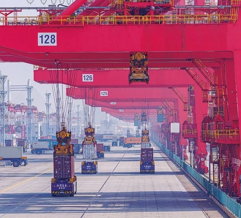 共建“一帶一路”國家在工作制度對(duì)接、技術(shù)標(biāo)準(zhǔn)協(xié)調(diào)、檢驗(yàn)結(jié)果互認(rèn)等方面強(qiáng)化合作、統(tǒng)一標(biāo)準(zhǔn)，貿(mào)易自由化便利化水平不斷提升。上海洋山港海關(guān)對(duì)接共建國家進(jìn)出口貨物相關(guān)標(biāo)準(zhǔn)，推動(dòng)通關(guān)一體化方式申報(bào)，提升通關(guān)效率。圖為無人駕駛的全自動(dòng)導(dǎo)引車在洋山港穿梭往來，搬運(yùn)集裝箱。王初 攝