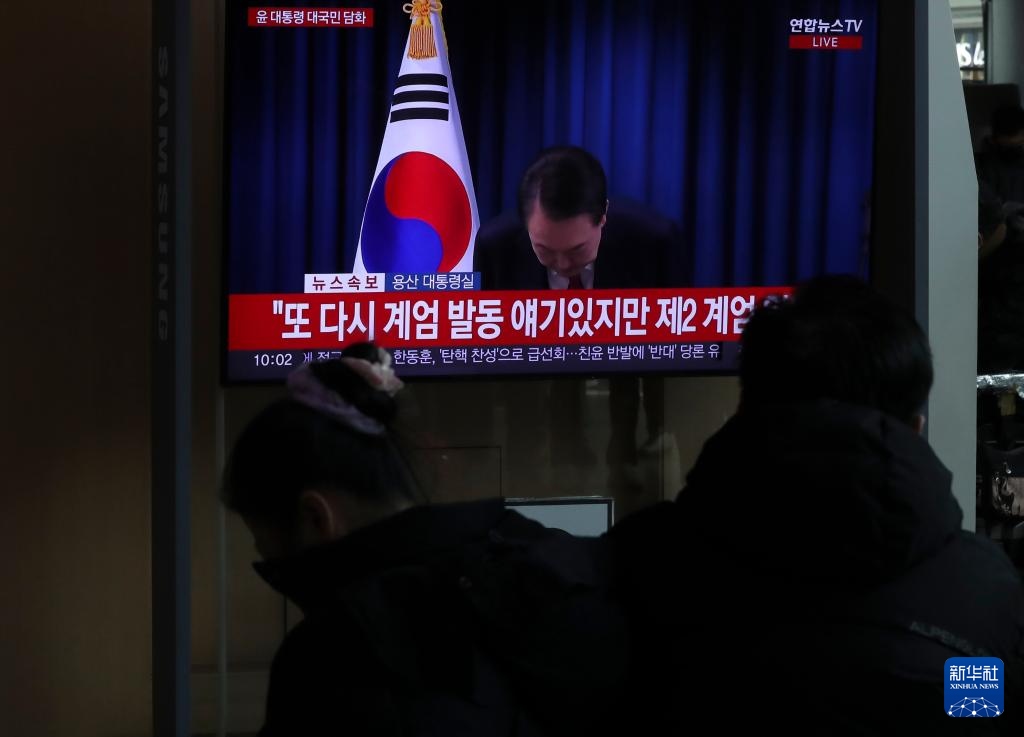 12月7日，在韓國首爾火車站，民眾觀看總統(tǒng)尹錫悅發(fā)表講話的電視畫面。新華社記者 姚琪琳 攝