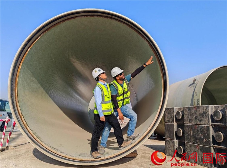 工作人員在察看輸水管情況。人民網(wǎng)記者 管克江攝