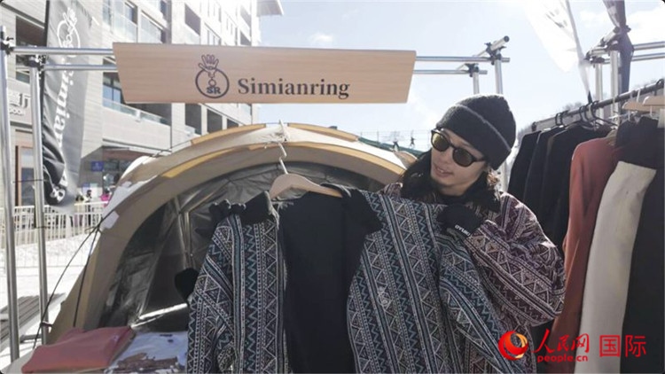 藤田周正在展示自己設(shè)計的滑雪服。人民網(wǎng)記者 袁蒙攝