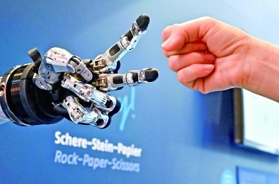 在德國漢諾威工博會(huì)上，參觀者與一款智能機(jī)器人進(jìn)行“石頭剪子布”游戲。新華社發(fā)