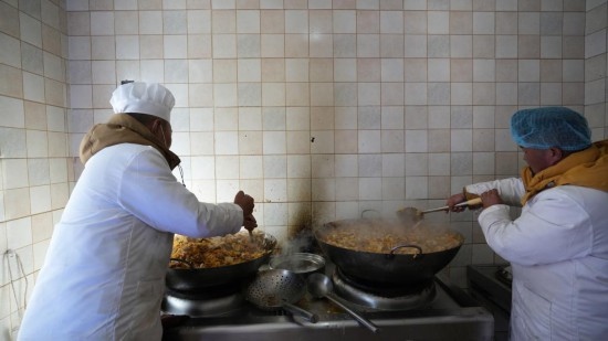 1月14日，服務(wù)隊的兩名廚師正在為村民們做午飯。新華社記者 邱星翔 攝