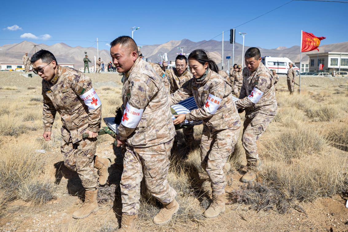 1月9日，日喀則定日縣長(zhǎng)所鄉(xiāng)，西藏軍區(qū)總醫(yī)院醫(yī)療隊(duì)隊(duì)員將受傷村民用擔(dān)架從救護(hù)車(chē)準(zhǔn)備抬上直升機(jī)，轉(zhuǎn)運(yùn)至拉薩的西藏軍區(qū)總醫(yī)院救治。人民日?qǐng)?bào)記者張武軍攝