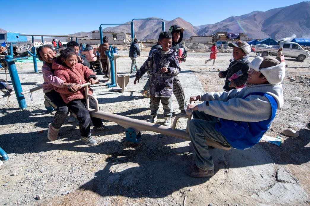 1月11日，在定日縣措果鄉(xiāng)塘仁村安置點(diǎn)，西藏星光社會(huì)工作服務(wù)中心志愿者和孩子們一起玩耍，進(jìn)行災(zāi)后心理疏導(dǎo)。人民網(wǎng)記者 翁奇羽攝