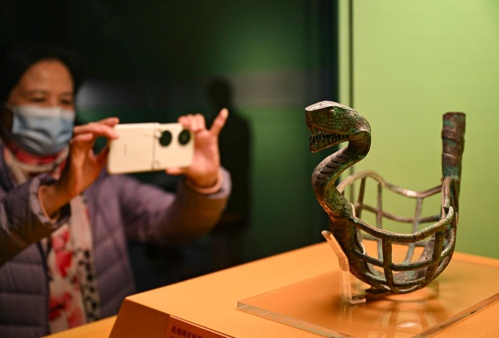 1月14日，觀眾在上海博物館蛇年迎春展拍攝展品蛇綱網(wǎng)狀銅器。新華社發(fā)（陳浩明攝）