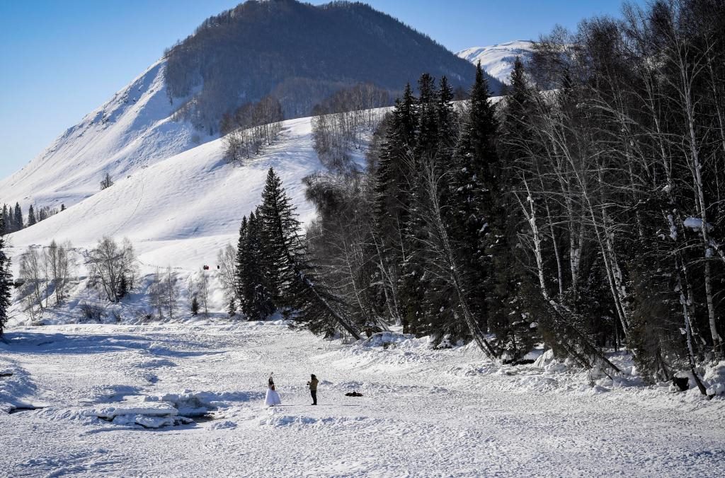 2024年2月5日，兩名游客在新疆阿勒泰地區(qū)布爾津縣禾木村拍照。新華社記者 馬鍇 攝
