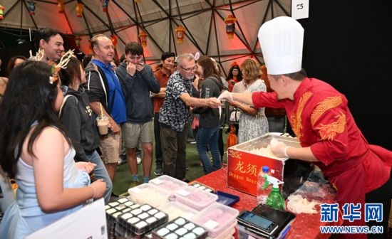 圖為游客在燈節(jié)現(xiàn)場(chǎng)購買小吃。（圖片由奧克蘭中國文化中心提供）