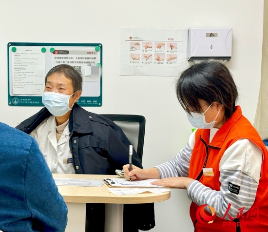 秦苑（中）接診患者。人民網(wǎng)記者 金慧慧攝