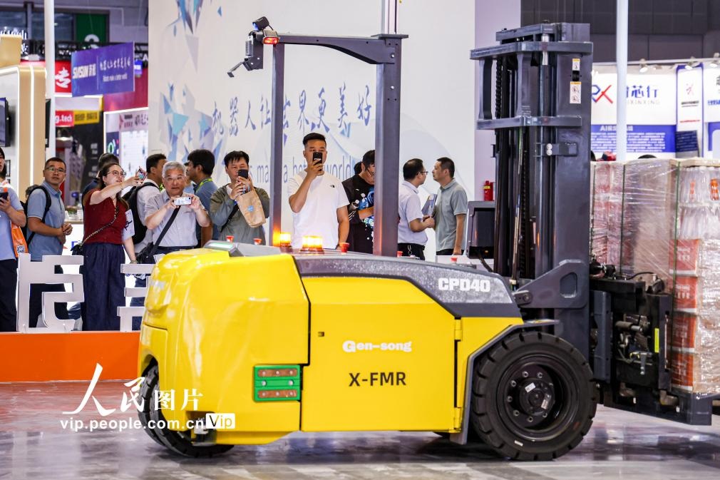 第24屆中國(guó)工博會(huì)現(xiàn)場(chǎng)，觀眾觀看叉取機(jī)器人作業(yè)演示。王初攝（人民圖片網(wǎng)）