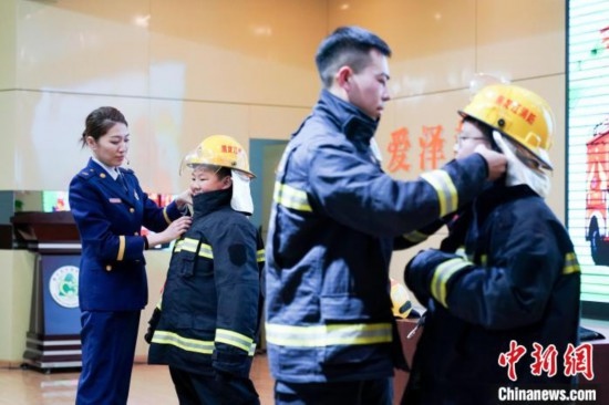 圖為學(xué)生們現(xiàn)場穿戴消防頭盔和戰(zhàn)斗服。中新社記者 趙宇航 攝