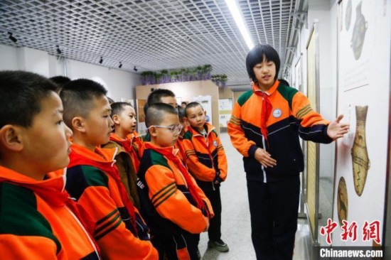 圖為學(xué)生通過展板了解出土于青海省海東市樂都區(qū)的辛店文化文物鹿紋彩陶甕。中新社記者 馬銘言 攝