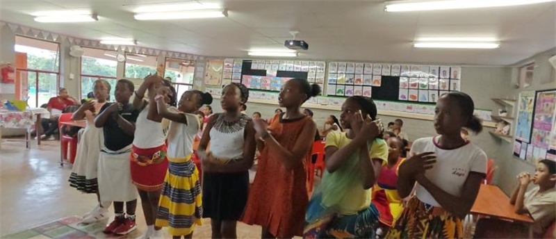南非學(xué)生展示民族服飾，合唱《聽我說謝謝你》。