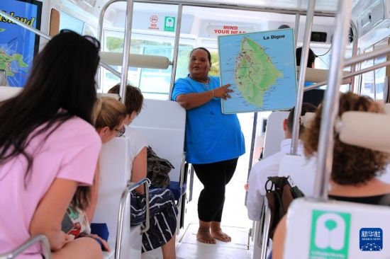 3月15日，一名導游在游艇上為游客介紹塞舌爾拉迪格島。新華社記者 董江輝 攝