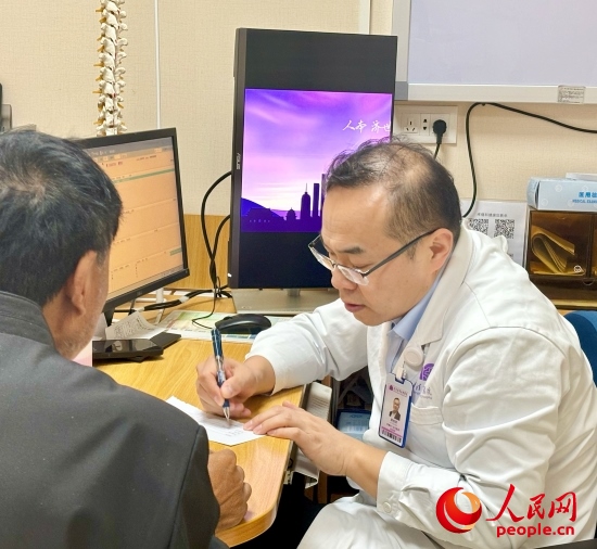 路桂軍接診時為患者寫下用藥提示。人民網記者 金慧慧攝