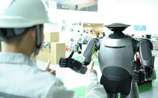 在廣汽研究院，人形機器人團隊的周仁義在演示GoMate機器人互動功能（新華社記者 鄧華 攝）