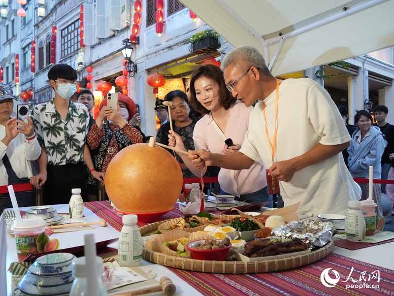 嘉賓品嘗海南傳統(tǒng)美食“煎堆”。人民網(wǎng)記者 張力洋攝