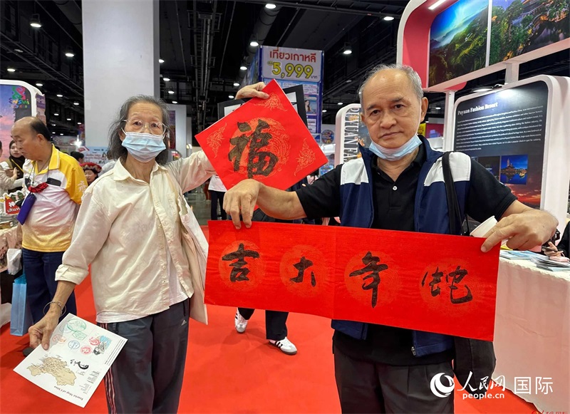 2025蛇年春節(jié)，泰國市民展示他們領(lǐng)到的華人手寫春聯(lián)。人民網(wǎng)記者 簡承淵攝