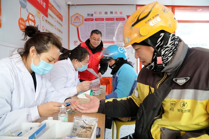 2025年3月5日，志愿者在山東省棗莊市市中區(qū)一工會驛站為外賣員免費測量血糖。新華社發(fā)（王海楠攝）