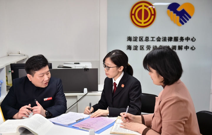 2025年3月6日，在北京市海淀區(qū)總工會勞動爭議調(diào)解中心，海淀區(qū)人民法院法官王琰（中）與該中心工作人員就糾紛化解情況進(jìn)行溝通。新華社記者 趙婷婷 攝