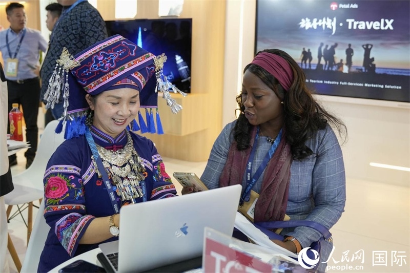 來(lái)自廣西的旅游業(yè)者同客戶交流。人民網(wǎng)塔里克·易卜拉欣攝