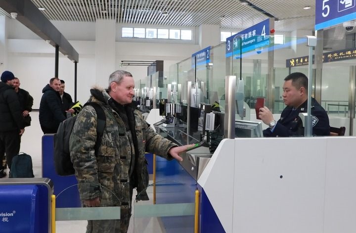 2024年12月10日，在黑河公路口岸旅檢大廳，黑河出入境邊防檢查站民警為首班次客車入境旅客辦理邊檢通關(guān)手續(xù)。當(dāng)日，中國黑河公路口岸—俄羅斯卡尼庫爾干公路口岸旅客運輸正式開通。新華社發(fā)（劉松攝）