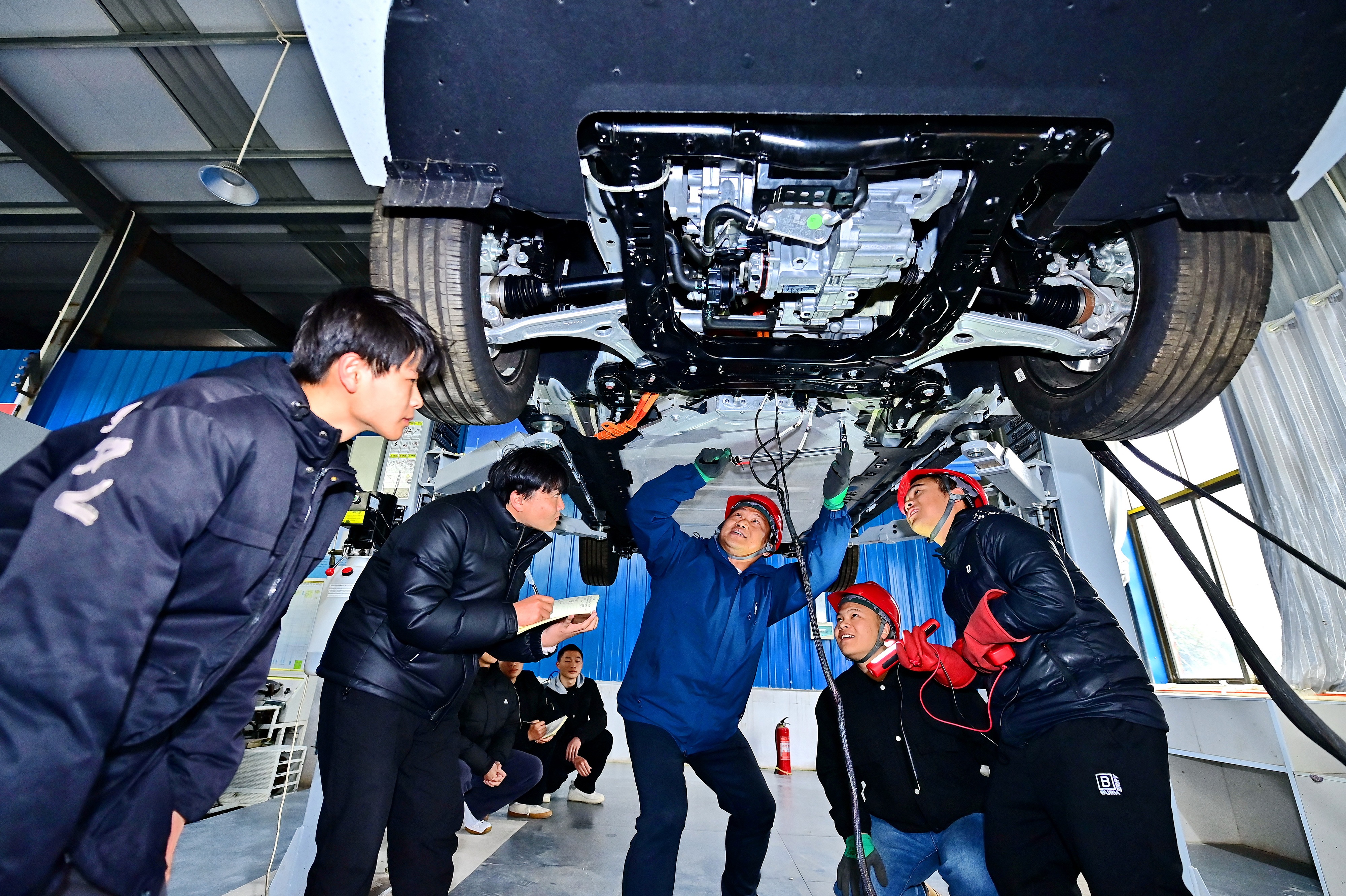 2025年2月，江西省宜春市，豐城市的一所技工學(xué)校實(shí)訓(xùn)基地內(nèi)，新能源汽車運(yùn)維專業(yè)學(xué)生在老師的指導(dǎo)下學(xué)習(xí)新能源汽車電池包檢修技術(shù)。