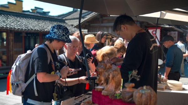 “五一”期間，游客正在烏鎮(zhèn)“水鄉(xiāng)碼頭”挑選購買文創(chuàng)產(chǎn)品。受訪者供圖