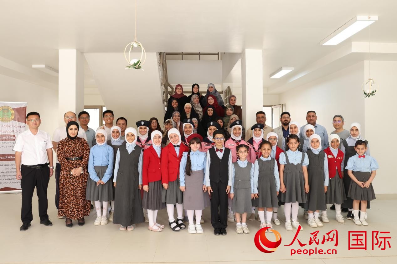 中國(guó)電建員工與阿爾穆塔?阿里卡特國(guó)際學(xué)校的師生及政府官員等合影。人民網(wǎng)記者 薛丹攝