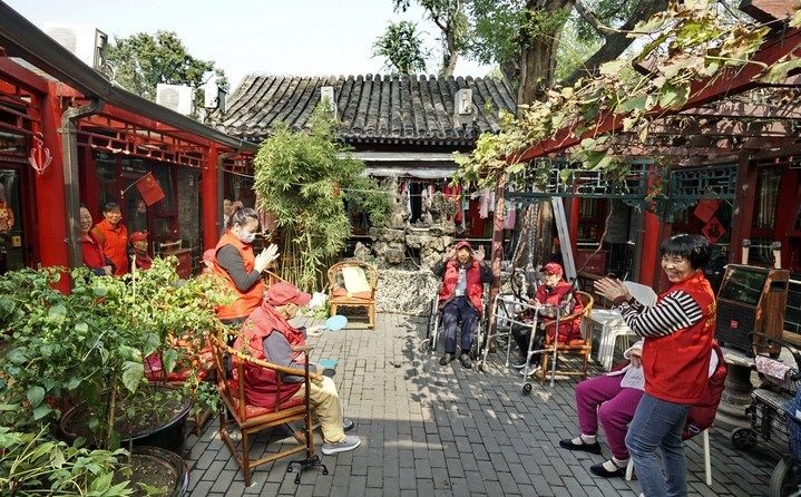 2024年10月12日，鐘樓灣胡同的老年人在社區(qū)內(nèi)的四合院養(yǎng)老驛站休閑。2017年起，北京市先后開展了兩輪背街小巷環(huán)境整治提升行動，完整保留了中軸線生活建筑群的歷史信息，并根據(jù)居民的生活和居住方式進(jìn)行適配化的更新和改造，極大地改善了生活環(huán)境。2023年鐘樓灣胡同被評為“北京最美街巷”。