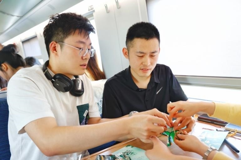 G232次旅客親手制作端午荷包和五彩繩。王磊攝