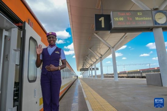 5月31日，在蒙內(nèi)鐵路內(nèi)羅畢站，一名乘務(wù)員在即將開(kāi)往蒙巴薩的E2次列車(chē)旁等候乘客。新華社記者 楊光 攝