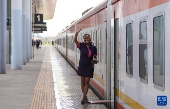 5月31日，在蒙內(nèi)鐵路內(nèi)羅畢站，一名乘務(wù)員在即將開(kāi)往蒙巴薩的E2次列車(chē)旁等候乘客。新華社記者 李亞輝 攝