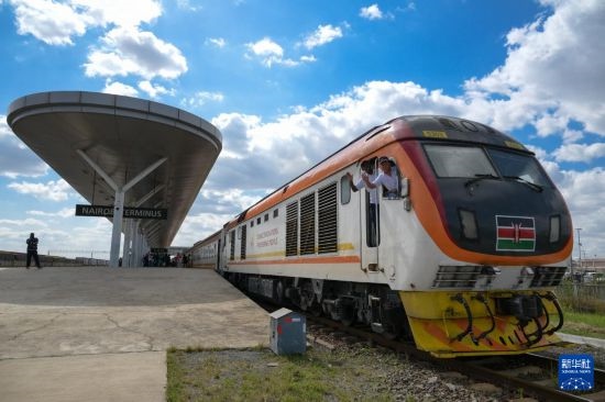 5月31日，在蒙內(nèi)鐵路內(nèi)羅畢站，機(jī)車(chē)駕駛員蔣立平（右）和博爾在即將開(kāi)往蒙巴薩的E2次列車(chē)上揮手致意。新華社記者 楊光 攝