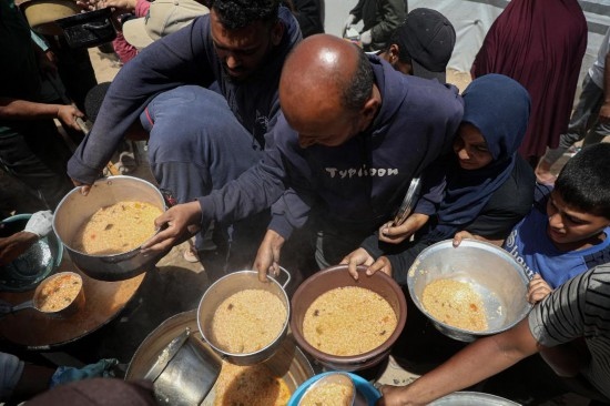 5月28日，人們在加沙城西部的沙提難民營領(lǐng)取救助食物。新華社發(fā)（里澤克·阿卜杜勒賈瓦德攝）